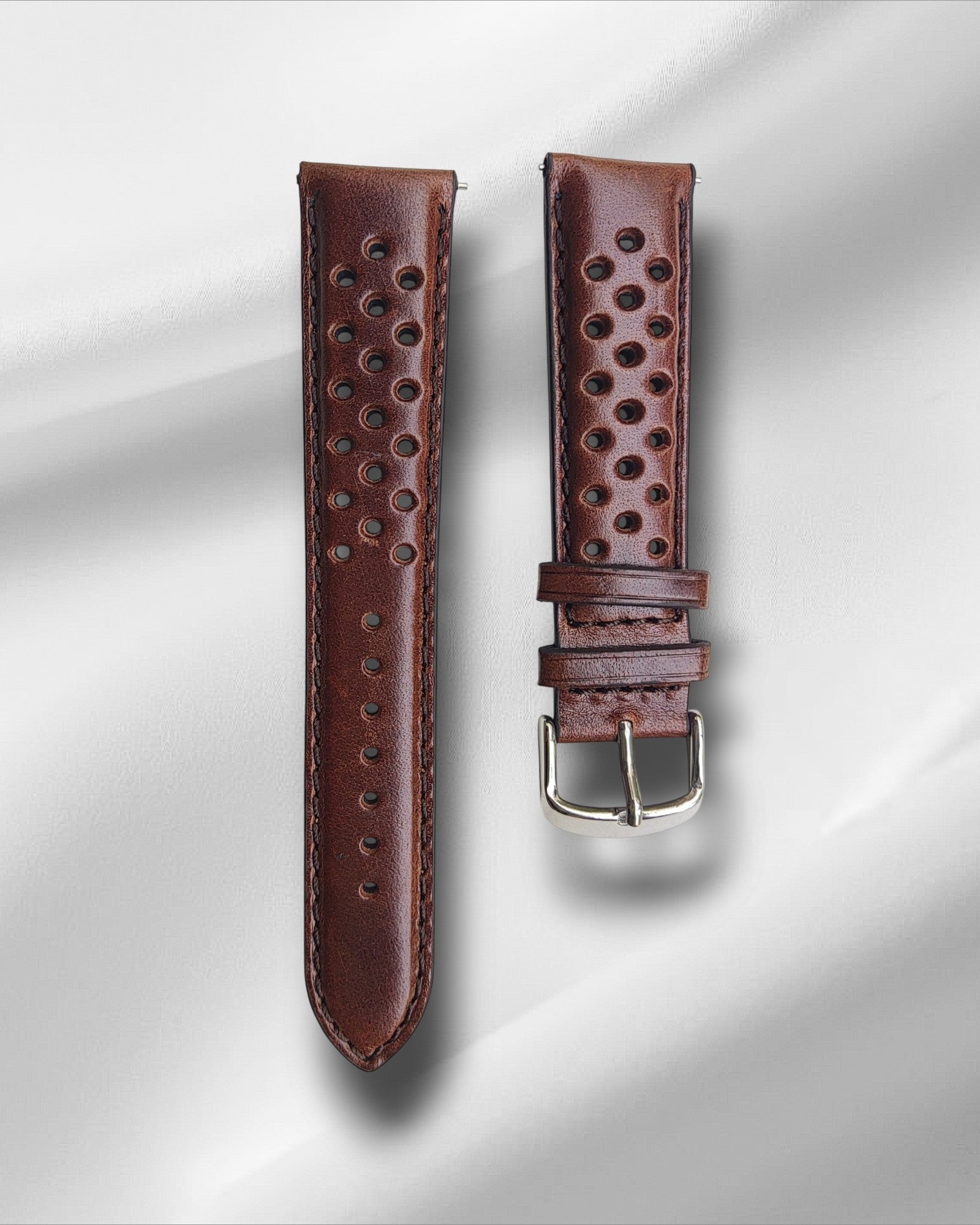 Brown racing watch strap with quick-release spring bars, displayed against a light background.