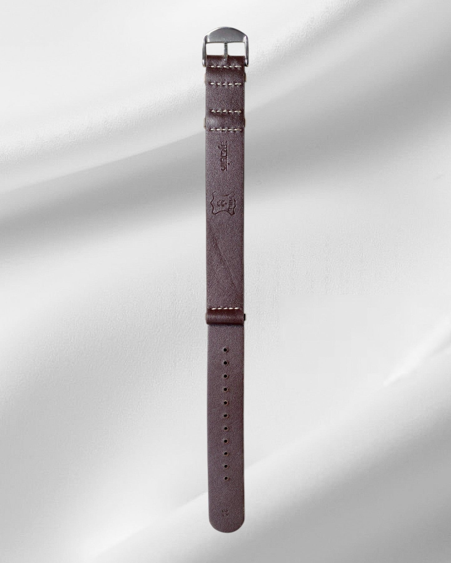 Brown watch strap with metal buckle on a light gray background
