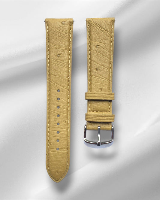 Beige watch strap with silver buckle on a light gray background