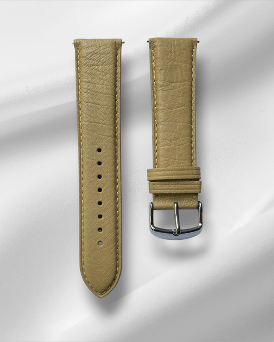 Beige leather watch strap with silver buckle on a light gray background