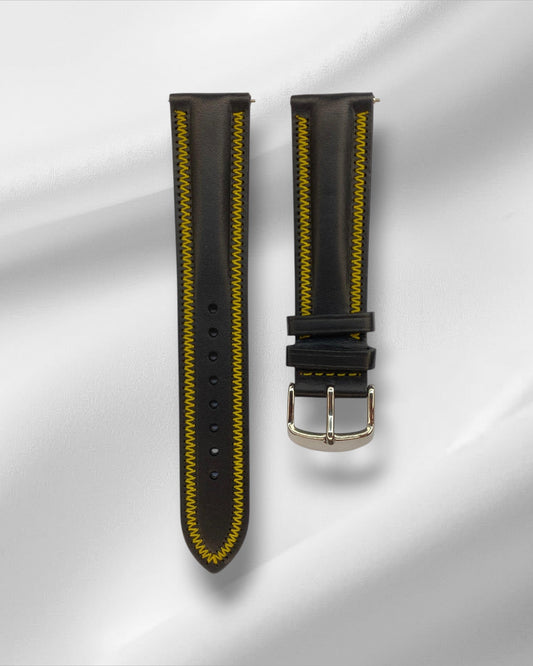 Black watch strap with yellow stitching on a gray background
