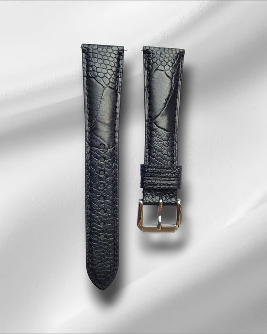 A black ostrich leg leather watch strap with a steel tang buckle and quick release spring bars, displayed on a white background.