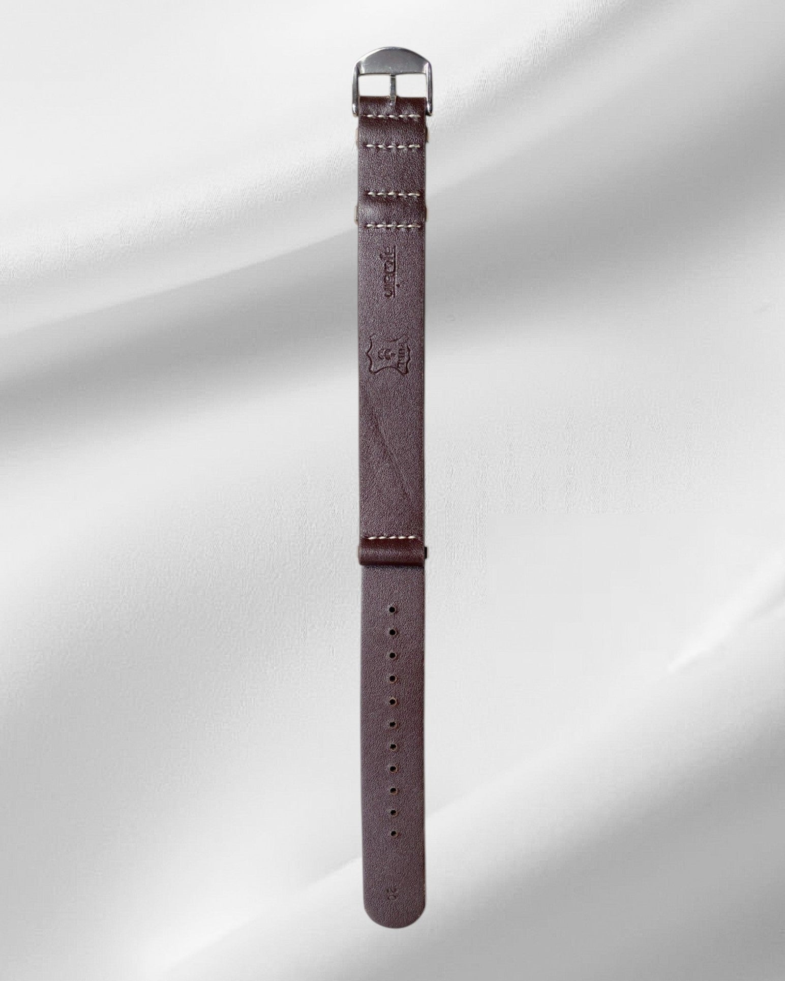 Brown watch strap with metal buckle on a light gray background