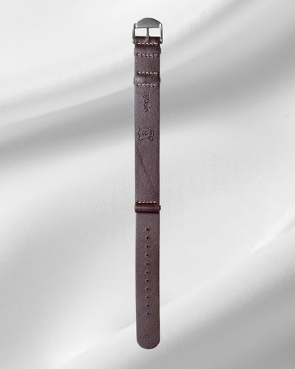 Brown watch strap with metal buckle on a light gray background
