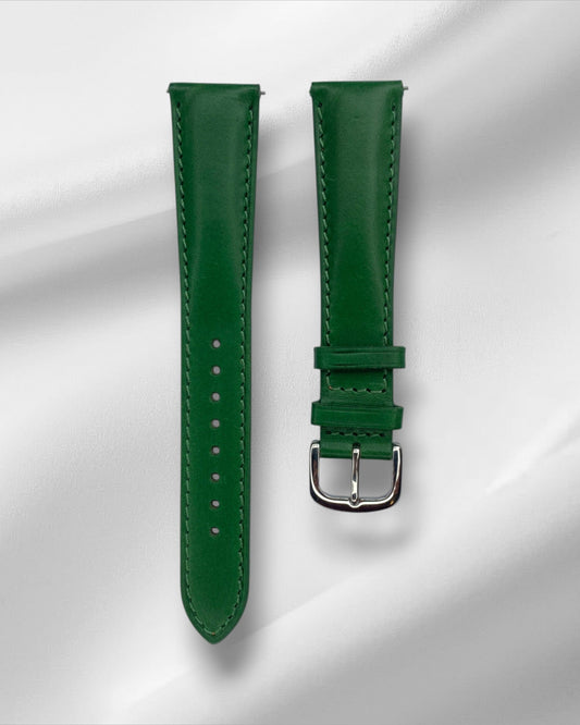 Green leather watch strap with silver buckle on a white background